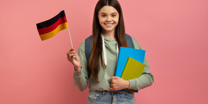 Eine Frau mit zwei Büchern und einer Deutschlandflagge in der Hand.