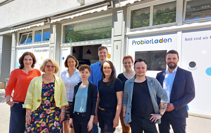 Pressefoto aller beteiligten Personen am Probierladen - Dorothea Prell, Smart City Beauftragte und Projektleiterin, vhs-Leiterin Dr. Angela Anding, Friedrun Vollmer, JenaKultur-Werkleiterin für Kulturentwicklung und Kulturelle Bildung, Stefanie Teichmann und Jan Wiescholek, beide Teilprojektleiter Handlungsfeld, Bildung, Kultur, Soziales, Sandra Laue, Projektkoordinatorin des „Probierladens“, Anna Geißler und Oliver Ephrosi, Medienpädagogen im „Probierladen“ und der für Digitalisierung zuständige Dezernent Benjamin Koppe