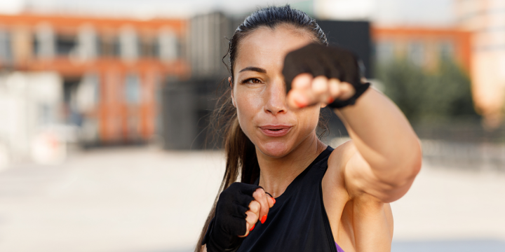 Eine Frau welche in die Kamera boxt