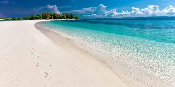 Meer mit weißen Sandstrand und blauen Himmel