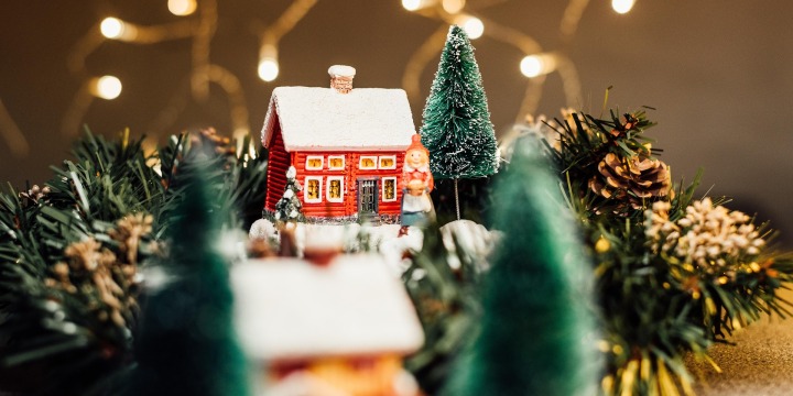 Kleines Gesteck mit einem Weihnachtshäuschen in der Mitte