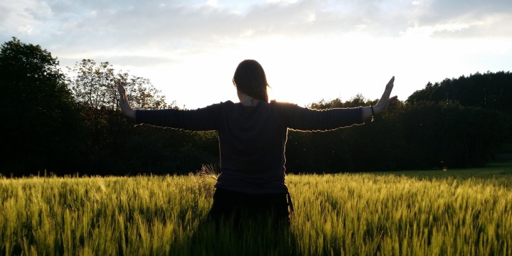 Grüne Wiese, Blauer Himmel und eine Dame die Übungen macht