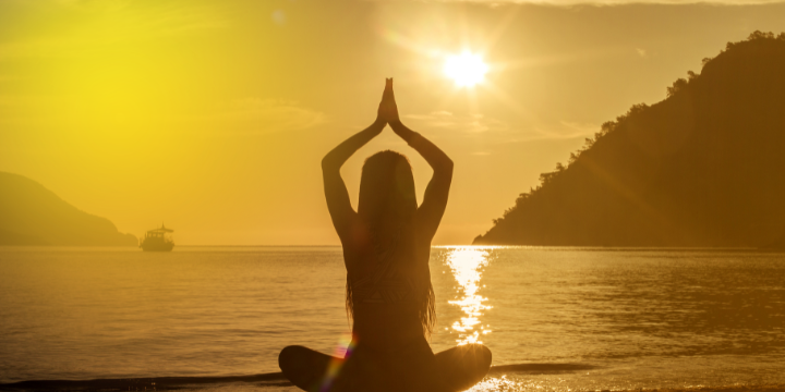 Sonnenuntergang am Strand mit einer Yogahaltung