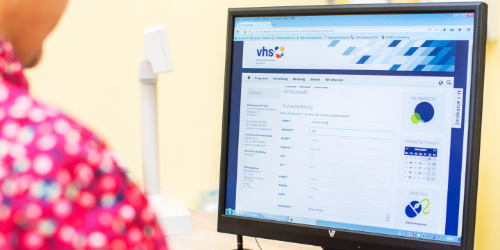 Mitarbeiter am PC auf der vhs Webseite