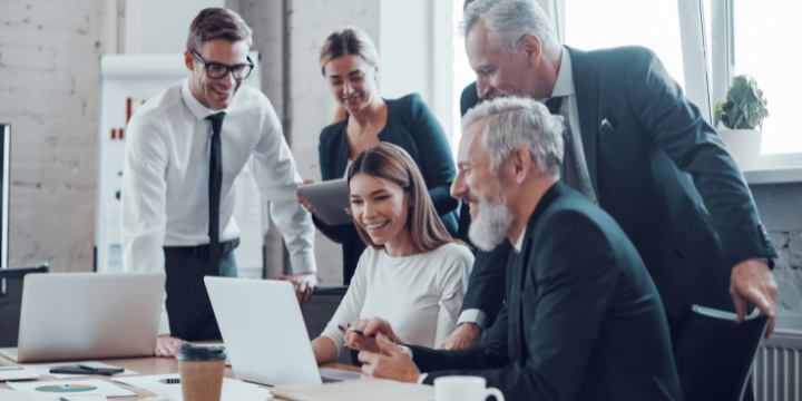 Menschen in einem Büro welche über einen Laptop sitzen